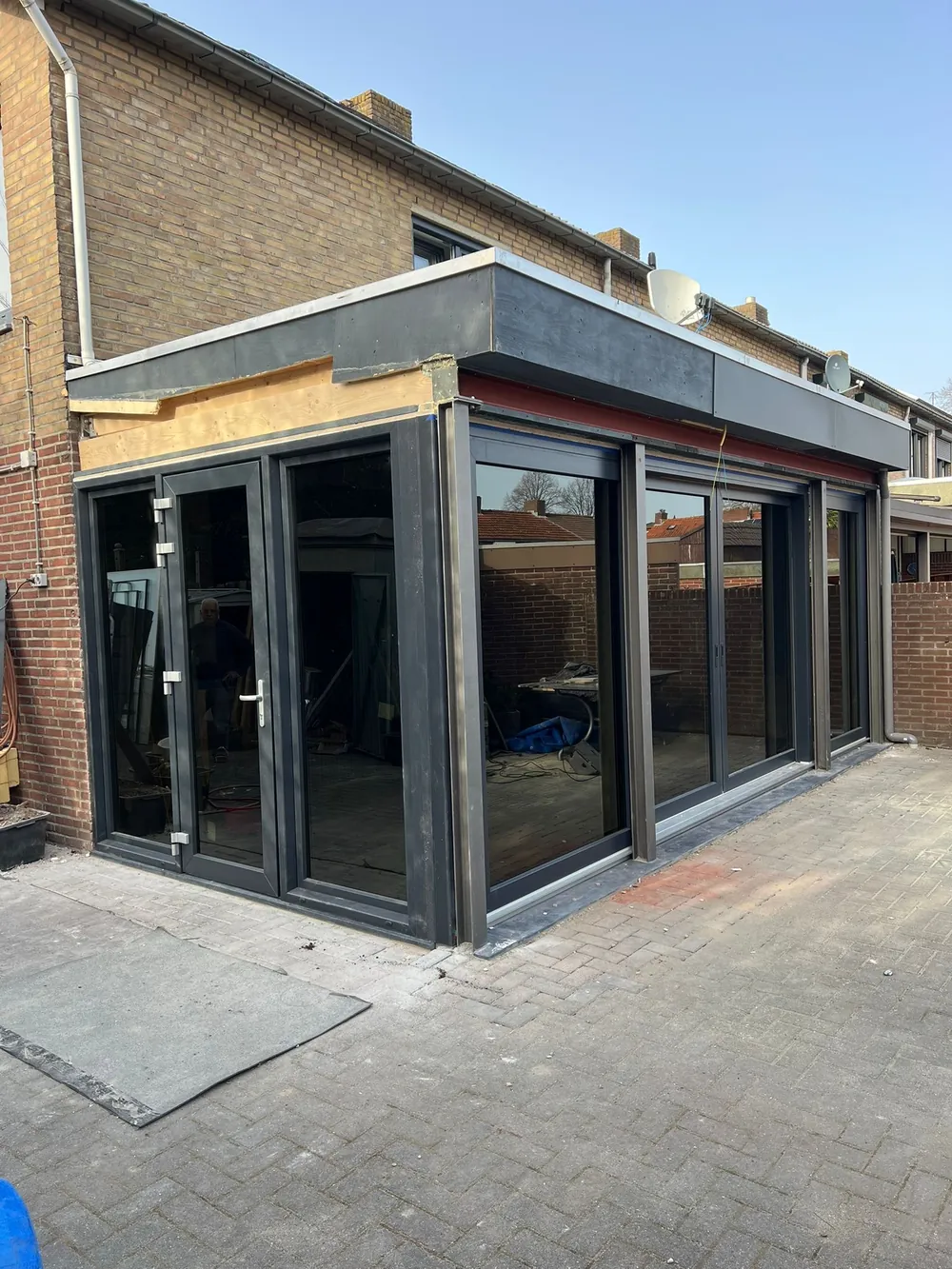 Aluminium uitbouw met schuifdeuren en vouwdeuren rondom